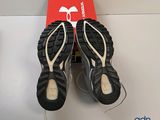 the pair of black sandals are sitting on top of a red box