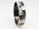 a close up of a ring on a white surface with black and white squares