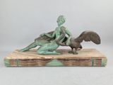 statue of a woman and a bird on a wooden base