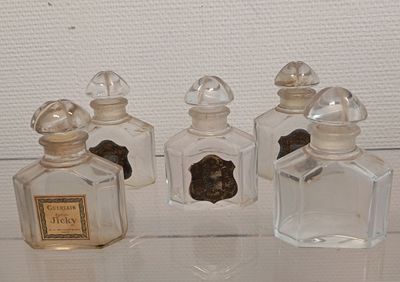 trois petites bouteilles en verre posées sur une table en verre