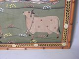 a picture of a painting of a cow with people in the background