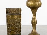 pair of brass vases with figures on them on a table