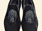 pair of black velvet slippers with a skull on the side