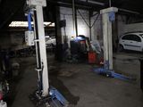 une voiture en cours de réparation dans un garage, sur un pont élévateur