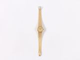 a wooden watch hanging on a wall on a white surface