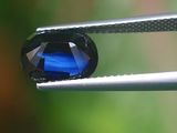 un gros plan d'un diamant bleu tenu par une pince