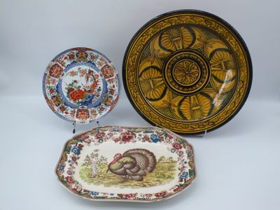 trois assiettes et un plat décorés d'un motif représentant une dinde