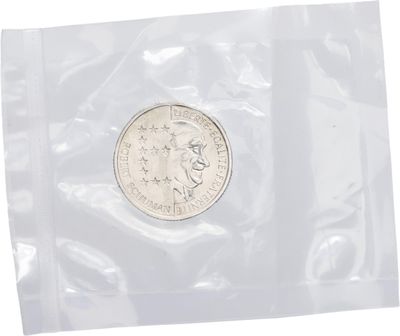 un gros plan d'une pièce de monnaie dans un sachet en plastique sur fond blanc