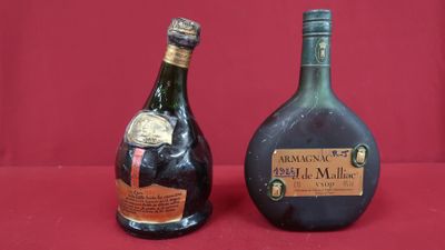 two bottles of liquor sitting next to each other on a red surface
