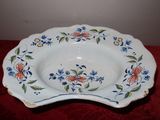 une assiette blanche décorée de fleurs bleues et orange