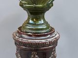 un buste en bronze représentant une femme assise sur un socle