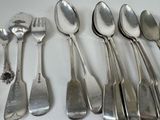 six spoons and a fork sitting on a table