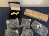 Plusieurs bijoux sont posés sur une table, à côté d'un rouleau de tissu
