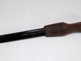 a black pen with a wooden handle on a white surface