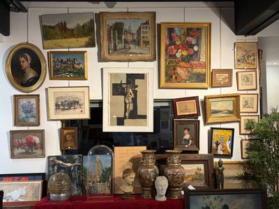 de nombreuses photos accrochées au mur d'une pièce où se trouve une table rouge