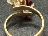 an image of a gold ring with a diamond and a garnett