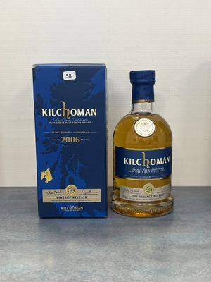La bouteille de Kilchomann se trouve à côté de la boîte, sur la table.