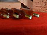 several bottles of wine are lined up on a red table cloth