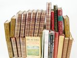 many books stacked on top of each other on a white surface