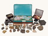 a suitcase full of rocks and stones on a white surface