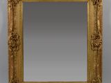 un miroir à cadre doré orné de sculptures raffinées sur les bords