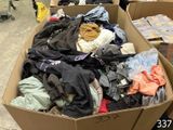 a cardboard box full of clothes in a room