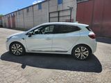 the rear end of a white car parked in front of a building