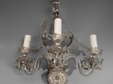 a crystal chandelier with three candles hanging from it