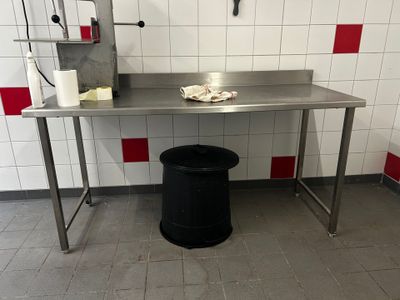 une table en métal sur laquelle se trouve une poubelle