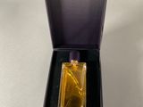 an open box with a perfume bottle inside of it on a white surface
