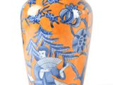 an orange vase with a blue and white design on it