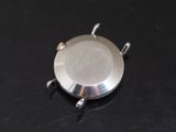 a silver plate with a handle on a black surface