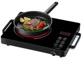 une photo d'une plaque de cuisson électrique noire sur laquelle sont disposés un steak et des légumes
