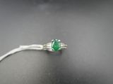 un gros plan d'une bague ornée d'une pierre verte sur un fond noir