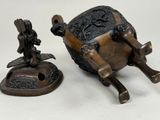 a small statue of a man riding a horse next to a small statue of a man on a horse