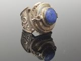 a close up of a silver ring with a blue stone