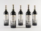 four bottles of wine are lined up on a white surface