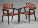 une paire de fauteuils en cuir avec des pieds en laiton et une assise tressée