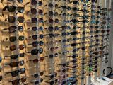 many different shades of sunglasses on display in a store