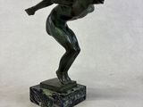 bronze statue of a man running on a marble base