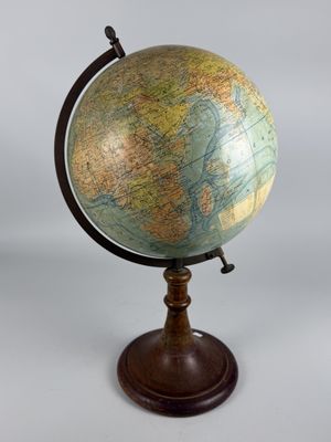 an old globe on a wooden stand with a white background