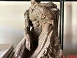 a statue of a man sitting on top of a book