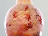 a glass vase with flowers painted on it sitting on a table