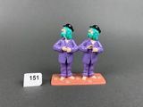 deux figurines représentant deux hommes vêtus de costumes violets et de chapeaux noirs
