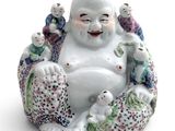 a statue of a laughing buddha sitting on a pillow