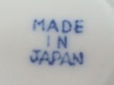 a white plate with blue writing on it that says made in japan