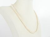 a close up of a white mannequin with a pearl necklace on it