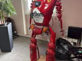 un robot rouge qui se tient debout sur une plate-forme en bois