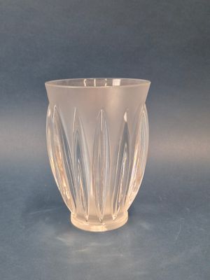 un vase en verre transparent posé sur une surface bleue