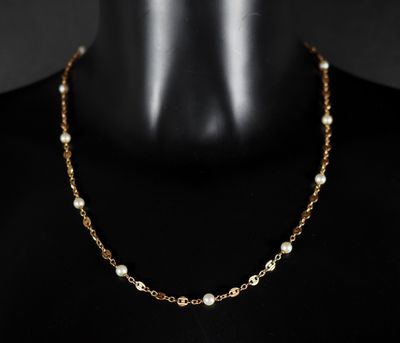 un collier à chaîne en or avec des perles sur un mannequin, un mannequin, un mannequin, un mannequin, un mannequin